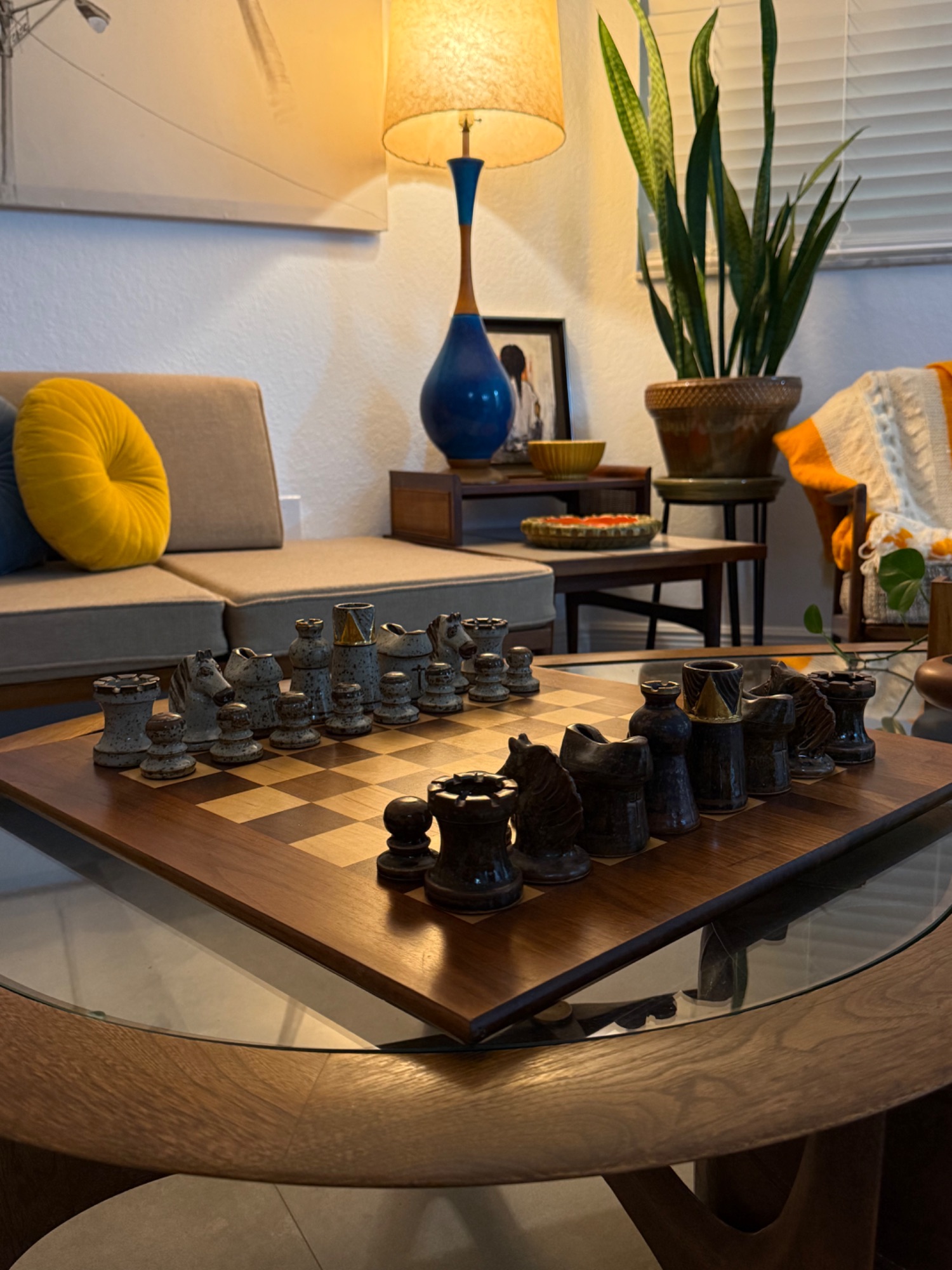 Chess set on glass coffee table at dusk